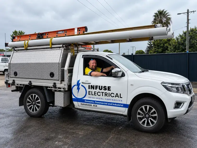 Infuse Electrical electrician leaning out of the driver's window of the branded Infuse Electrical ute